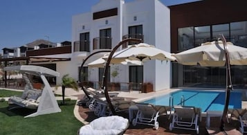 Una piscina al aire libre de temporada, sombrillas