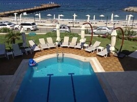 季节性开放的室外游泳池，09:00 至 09:30 开放，池畔遮阳伞，日光浴躺椅