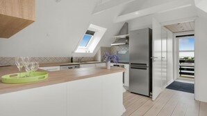 Una cocina moderna con tragaluz, refrigerador de acero inoxidable y encimera de madera.