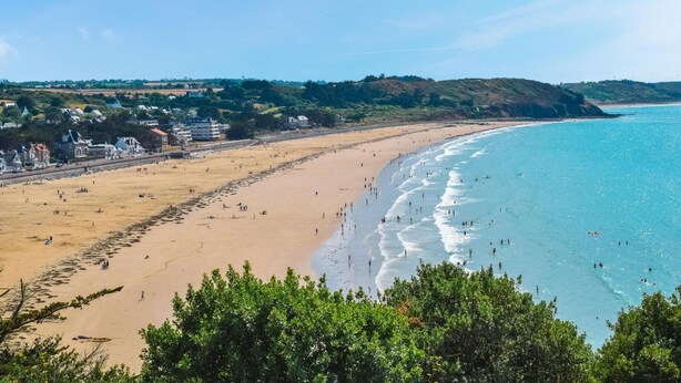 A beach with clear blue water, sandy shore, and buildings in the background. - Amazing home in Erquy with heated swimming pool (Erquy)