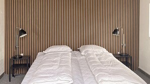 A double bed with white bedding, two bedside tables with lamps, and a wooden slat headboard. - Gorgeous home in Hemmet with WiFi (Hemmet)