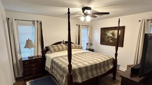 A bedroom with a four-poster bed, a ceiling fan, a painting on the wall, and a dresser. - Dolphin Place | Spacious home/ backyard and centrally located | 3 Bed | 2 Bath | (Corpus Christi)