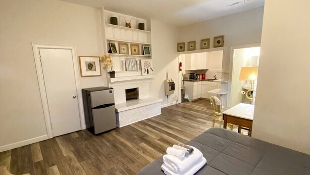 A compact hotel room with a bed, a small kitchenette, a fireplace, and a dining area. - Stylish Studio Apartment in Downtown Lexington (Lexington)