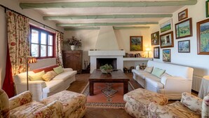 A cozy living room with two sofas, a wooden coffee table, and a fireplace. - La Jara Gaucín by Ruralidays (Málaga)