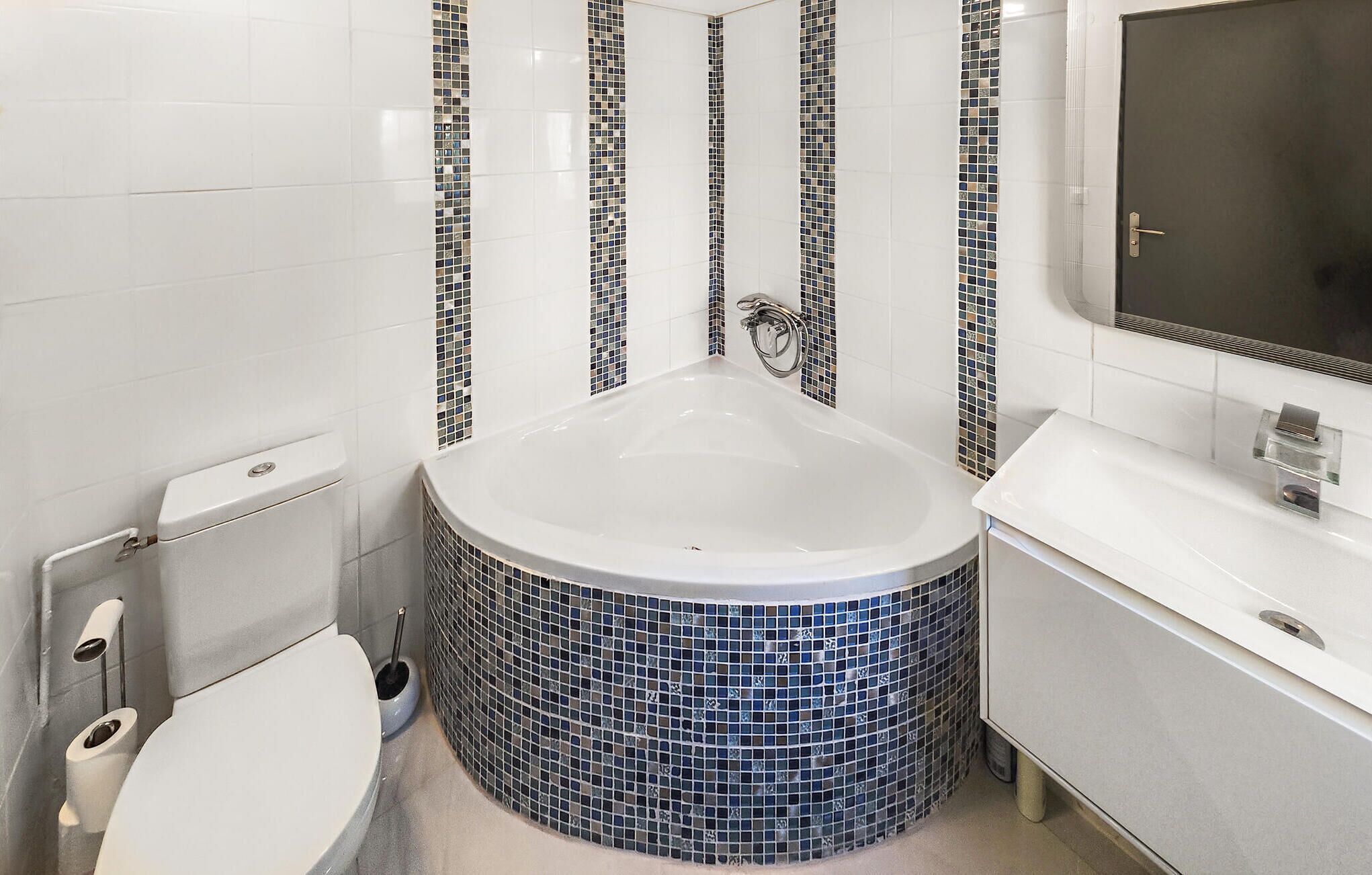 A bathroom with a freestanding bathtub, a toilet, and a sink.
