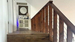 Eine hölzerne Treppe mit Geländer und einer weißen Tür am oberen Ende.
