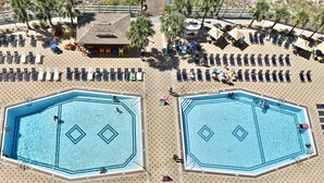 An aerial view of a resort with two large octagonal swimming pools, sun loungers, and palm trees. - Summit Penthouse 3BR 3BA VERY RARE!! (Panama City Beach)