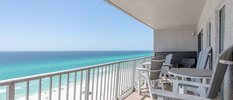 A balcony with a view of the beach and ocean.