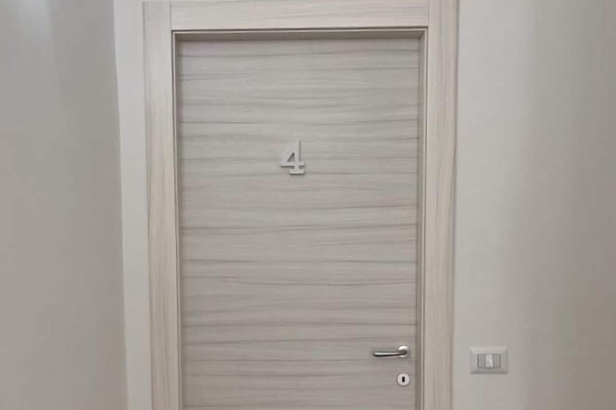 Una puerta cerrada con el número 4, un picaporte y un candado.