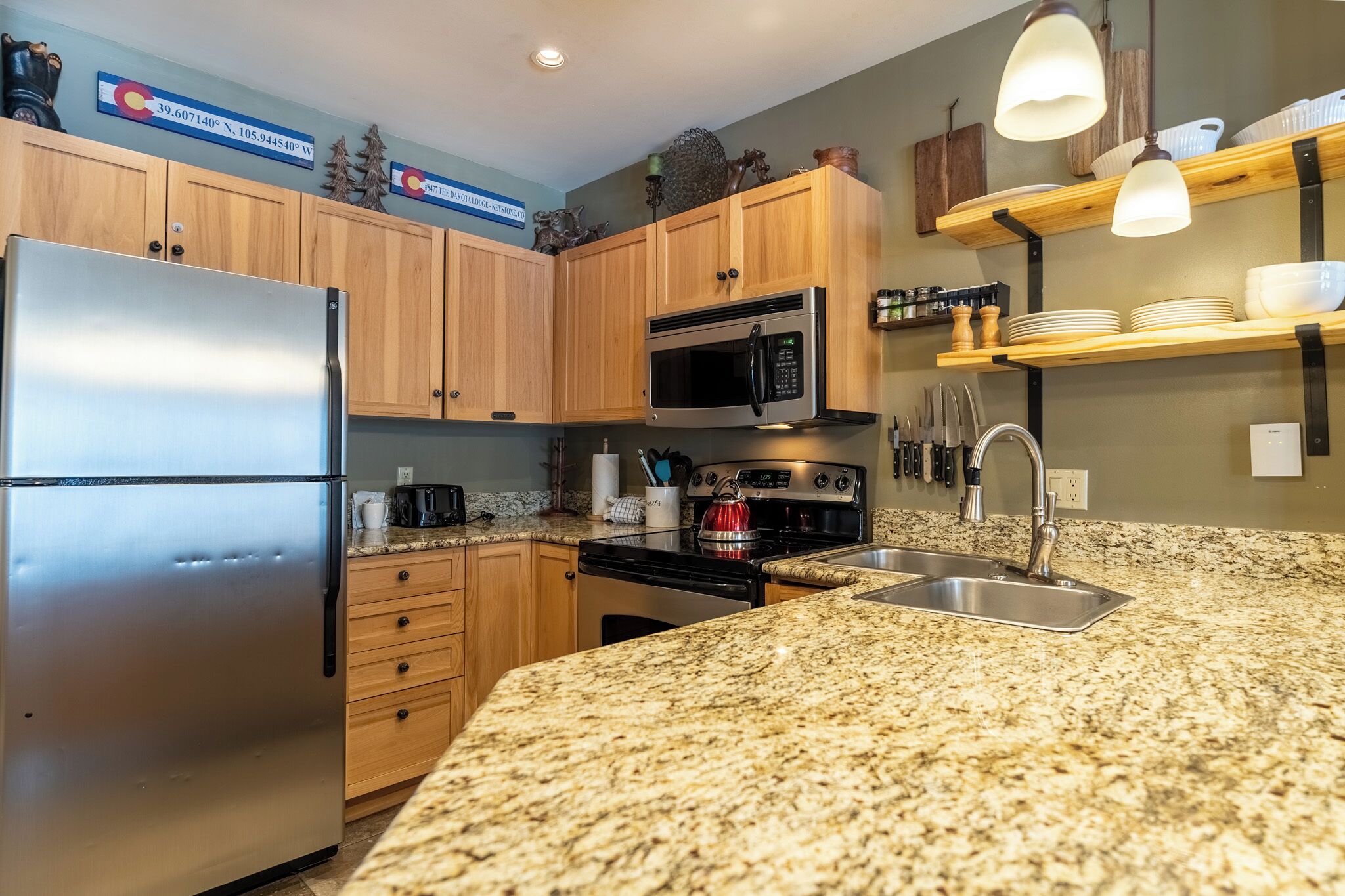 A kitchen with wooden cabinets, stainless steel appliances, granite countertops, and a built-in oven.