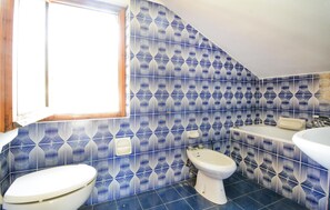 A bathroom with a geometric tile pattern, a window, a toilet, and a sink. - 3 bedroom stunning home in Ponzone (Ponzone)