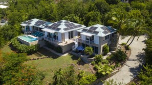 Ein modernes, zweistöckiges Haus mit Swimmingpool und Solaranlage auf dem Dach.