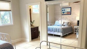 Een slaapkamer met een bed, een bureau en een televisie.