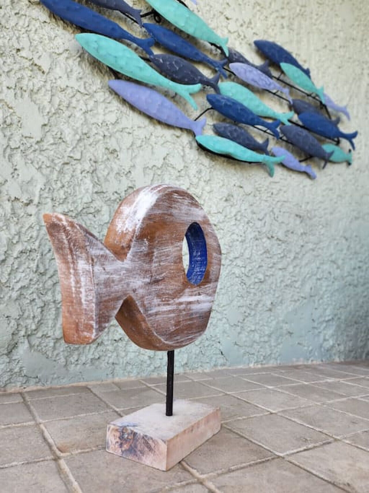 A wooden fish sculpture on a pedestal.