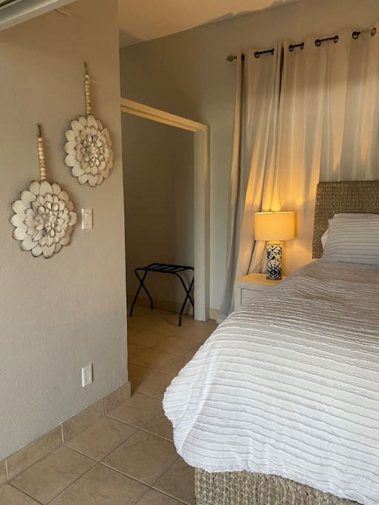 Une chambre à coucher avec un lit, une lampe de chevet et des éléments de décoration murale.