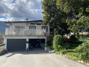 A two-story house with a balcony, a garage, and a well-maintained garden. - Magical Themed Decor! Pets Welcome! 3 Bedrooms (Chase)