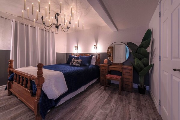 A bedroom with a wooden bed, a desk, a chair, a large mirror, and a potted plant. - Magical Themed Decor! Pets Welcome! 3 Bedrooms (Chase)
