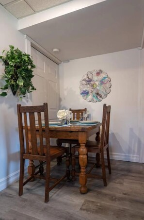 A dining area with a wooden table and chairs, a decorative wall piece, and a potted plant. - Magical Themed Decor! Pets Welcome! 3 Bedrooms (Chase)