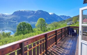A wooden deck with a view of a lake and mountains.