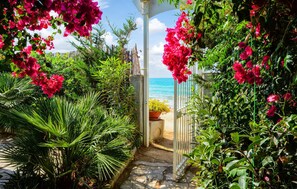 A garden pathway leading to a beach, surrounded by lush greenery and vibrant flowers. - 2 bedroom gorgeous home in Sciacca (Sciacca)