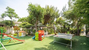 Ein Spielplatz mit Rutsche, Klettergerüst und einem Tischtennis-Tisch.