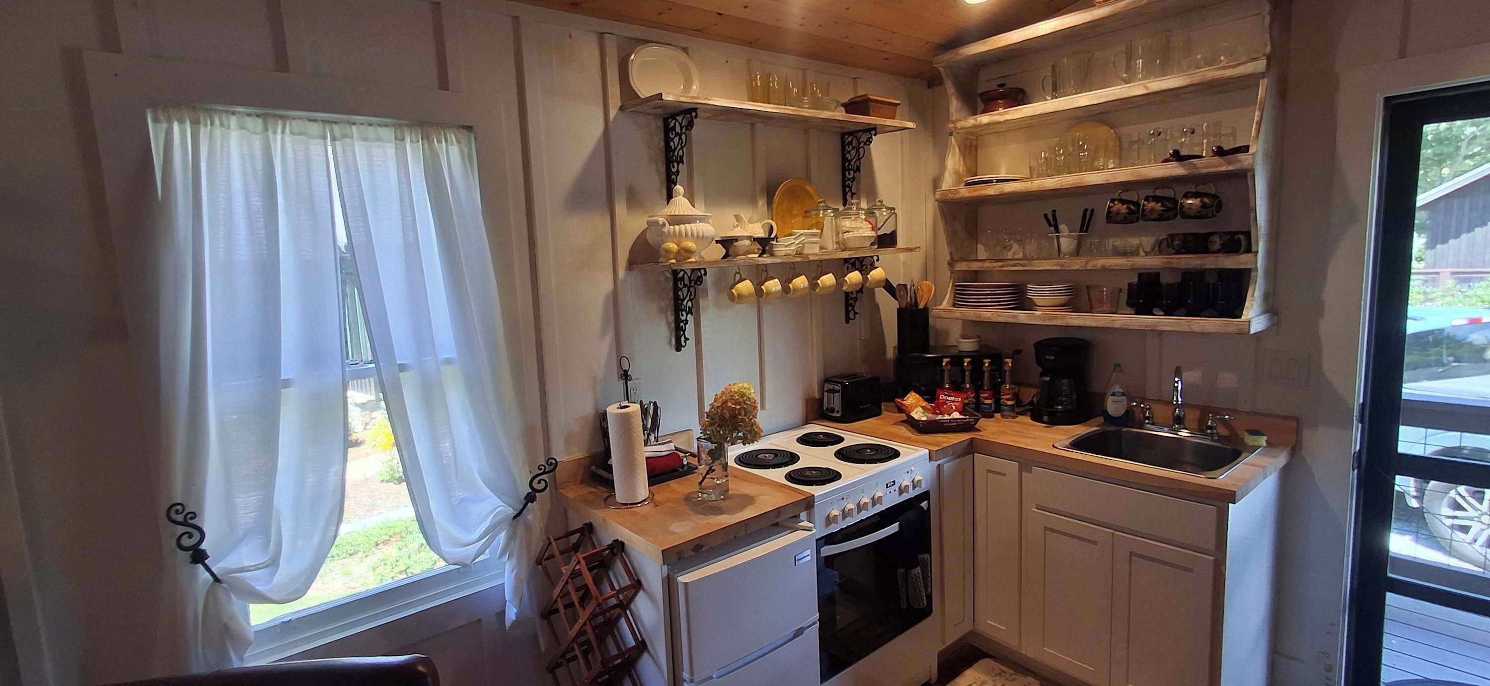 Coffee/tea maker, fridge, stovetop, cookware/dishes/utensils