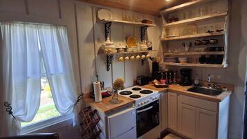 Coffee/tea maker, fridge, stovetop, cookware/dishes/utensils