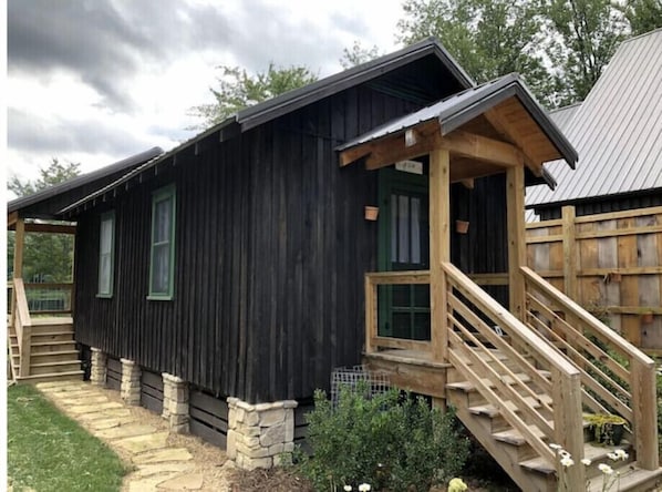 Un rifugio rustico con una scala in legno che conduce a un portico.