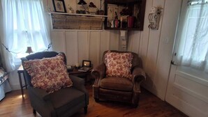 A cozy living room with a sofa, armchair, and a small table with a lamp. - The Cedar Cabin | Lake Views, Walk to Cashiers (Cashiers)