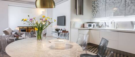 A modern kitchen with a marble island, stainless steel appliances, and a decorative wall panel.
