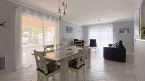 Uma área de refeições com mesa, cadeiras, um sofá e uma televisão.