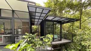 Une maison moderne dotée d’un balcon donnant sur un jardin luxuriant.