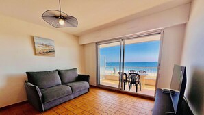 A balcony with a view of the sea, a sofa, and a TV stand. - QUIBERON - 2 rooms of about 38m² for 4 people SEA VIEW (QUIBERON)