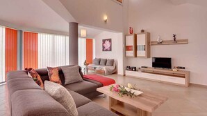 A modern living room with a sofa, coffee table, and a TV on a wooden cabinet. - Villa mit Pool und Klimaanlage (Pula)
