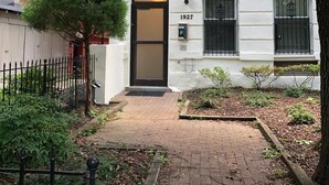 A two-story building with a white facade and a black door, numbered 1927. - Beautifully Renovated DuPont Circle Studio (Washington)