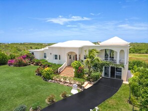 A two-story house with a white exterior, a covered porch, and a black driveway.
