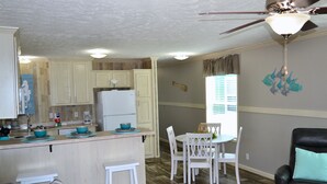 A compact living space with a kitchen, dining area, and seating area. - Sum Beaches Paradise Cottage 1 (Navarre)