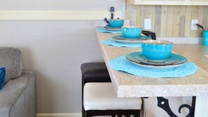 A kitchen with a wooden countertop, a blue bowl on a placemat, and a life ring on the wall.