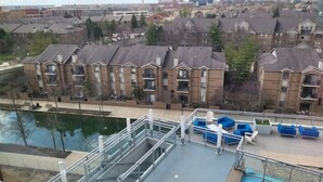 A residential area with apartment buildings, a swimming pool, and a view of the cityscape.