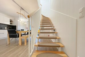 Een modern interieur met een houten trap, een eethoek en een keuken.