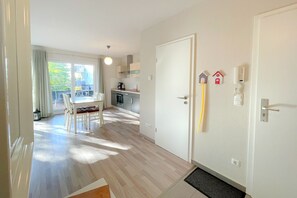 Eine helle, moderne Küche mit Essbereich, Holzboden und Blick ins Freie.