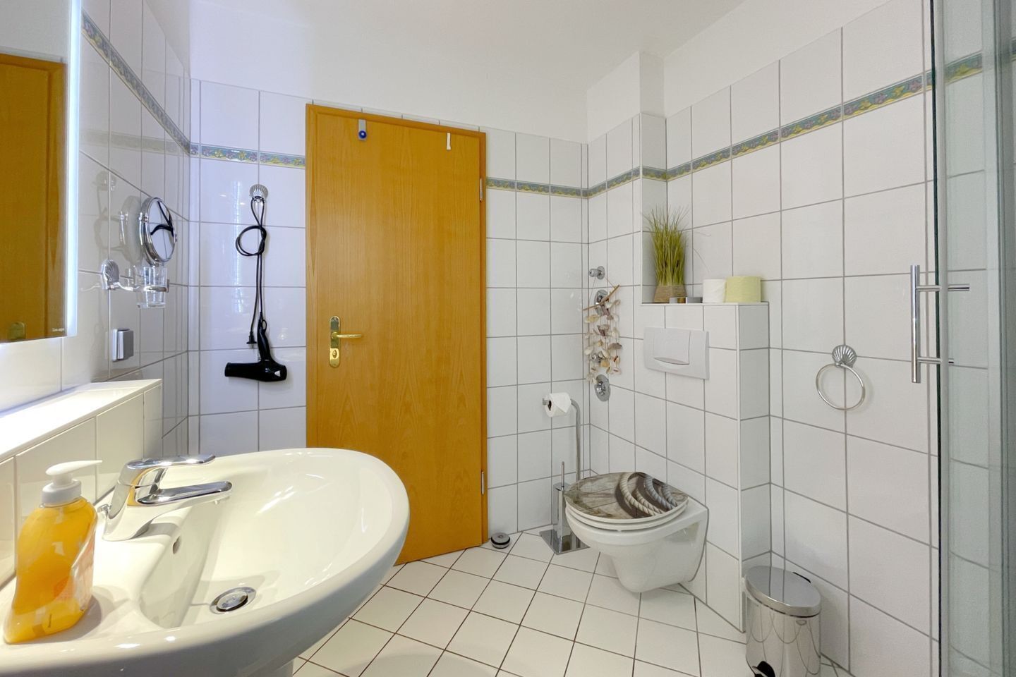 A bathroom with a sink, toilet, and shower.