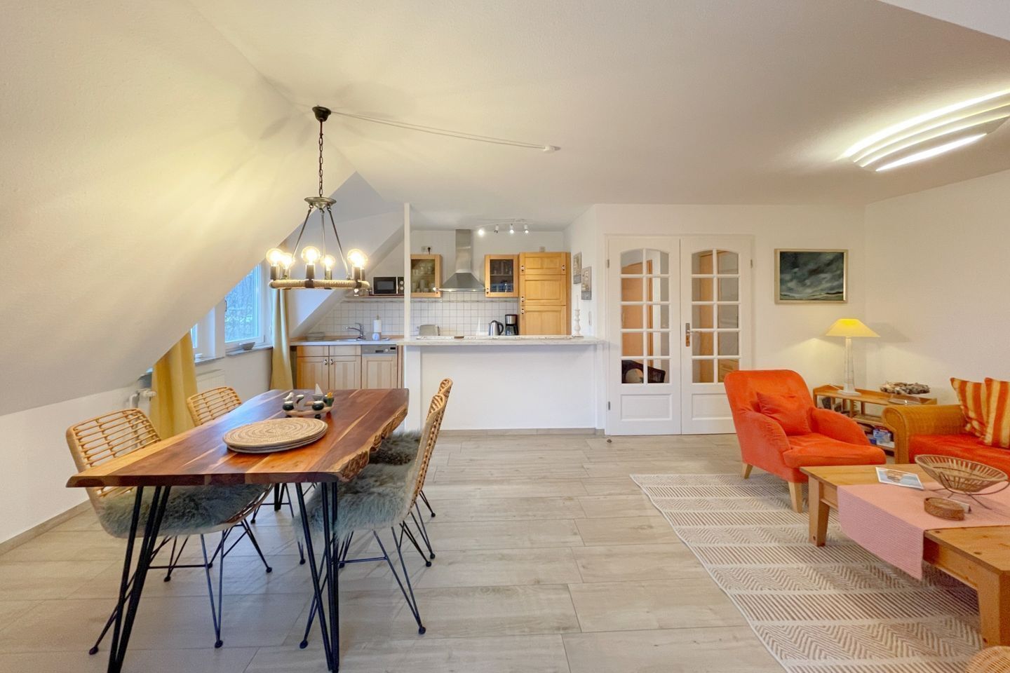 A modern apartment with a dining area, kitchen, and living space.