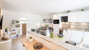 Un appartement moderne comprenant une cuisine, un coin repas et un salon.