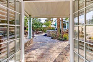 An open patio with stone flooring, outdoor furniture, and a view of the backyard. - Florida Breeze (St. Augustine)