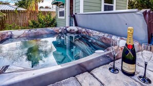 A hot tub with a bottle of Moët & Chandon champagne and two glasses on a stone surface. - Florida Breeze (St. Augustine)