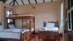 A room with two wooden bunk beds, a window with curtains, and a door with a curtain. - Hotel Casa san rafael  (Villa de Leyva)