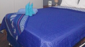 Ein Hotelzimmer mit einem Bett, einem Kleiderschrank und einem Nachttisch mit Lampe.