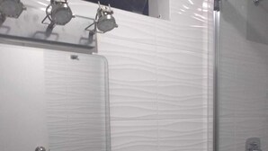 Ein Badezimmer mit Waschbecken, Spiegel und Dusche.