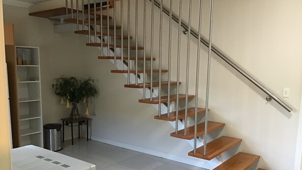 A staircase with wooden steps and metal railings, leading to an upper floor. - Large one bedroom Cottage in the heart of St Marys (Saint Marys)